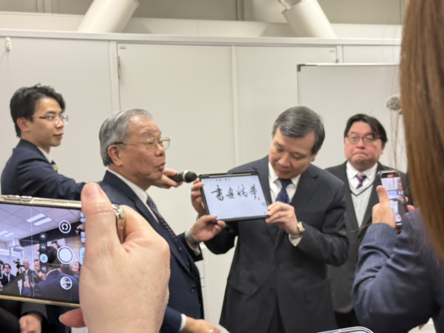 ◎駐日大使李逸洋(右)於張炳煌主任(左)講解 e筆書法時,為其手持平板 ◎駐日大使李逸洋(右)於張炳煌主任(左)講解 e筆書法時,為其手持平板